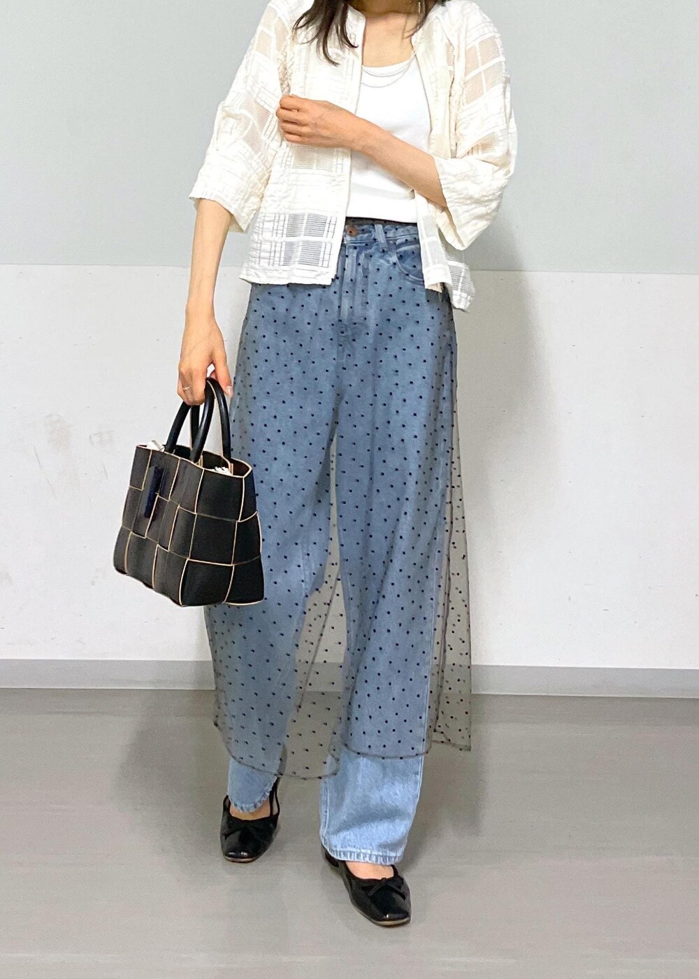 ブラック系のトートバッグ、ホワイト系のタンクトップ、グレー系のスカートを着用したレディースの夏コーディネートの6枚目の写真