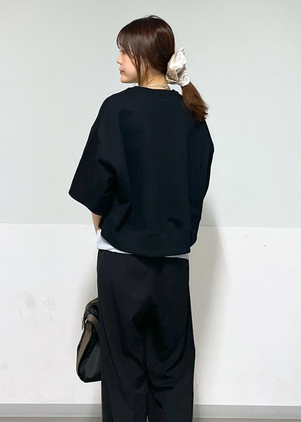 ブラック系のスラックス、シルバー系のサンダル、ブラック系のトートバッグを着用したレディースの夏コーディネートの4枚目の写真