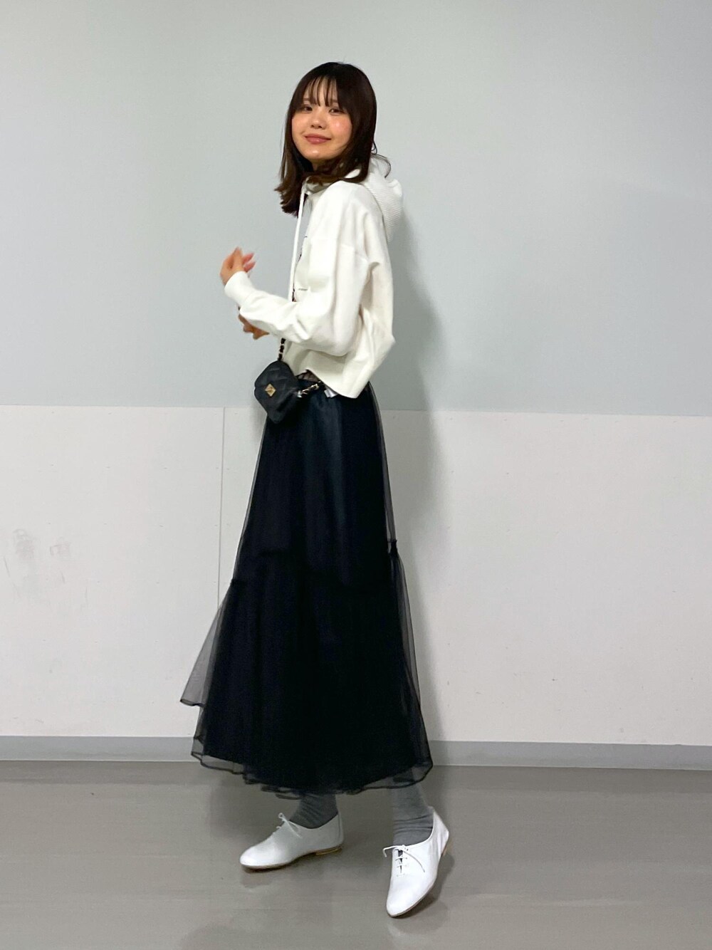 ブラック系のショルダーバッグ、ホワイト系のニット/セーター、ブラック系のスカートを着用したレディースの冬コーディネートの8枚目の写真