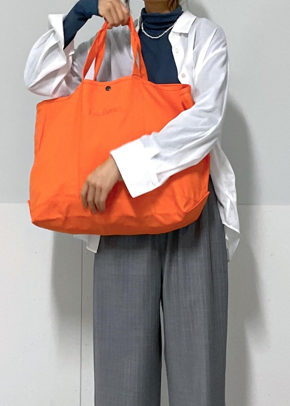 ブルー系のTシャツ/カットソー、グレー系のスラックス、ホワイト系のシャツ/ブラウスを着用したレディースの夏コーディネートの8枚目の写真