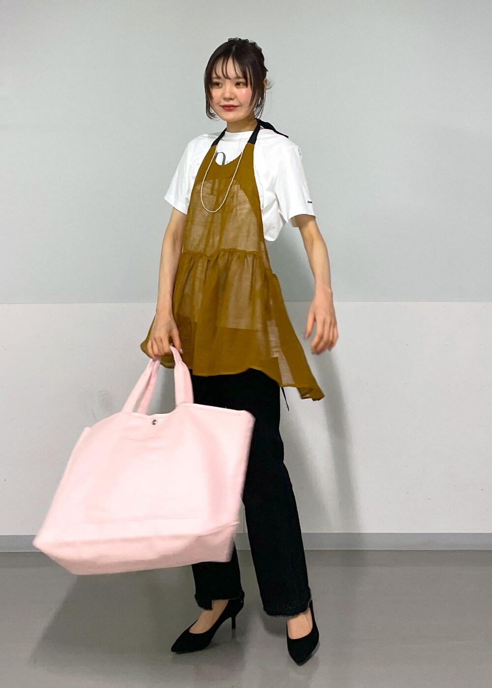 グレー系のデニムパンツ、ホワイト系のTシャツ/カットソー、ブラウン系のベストを着用したレディースの春コーディネートの6枚目の写真