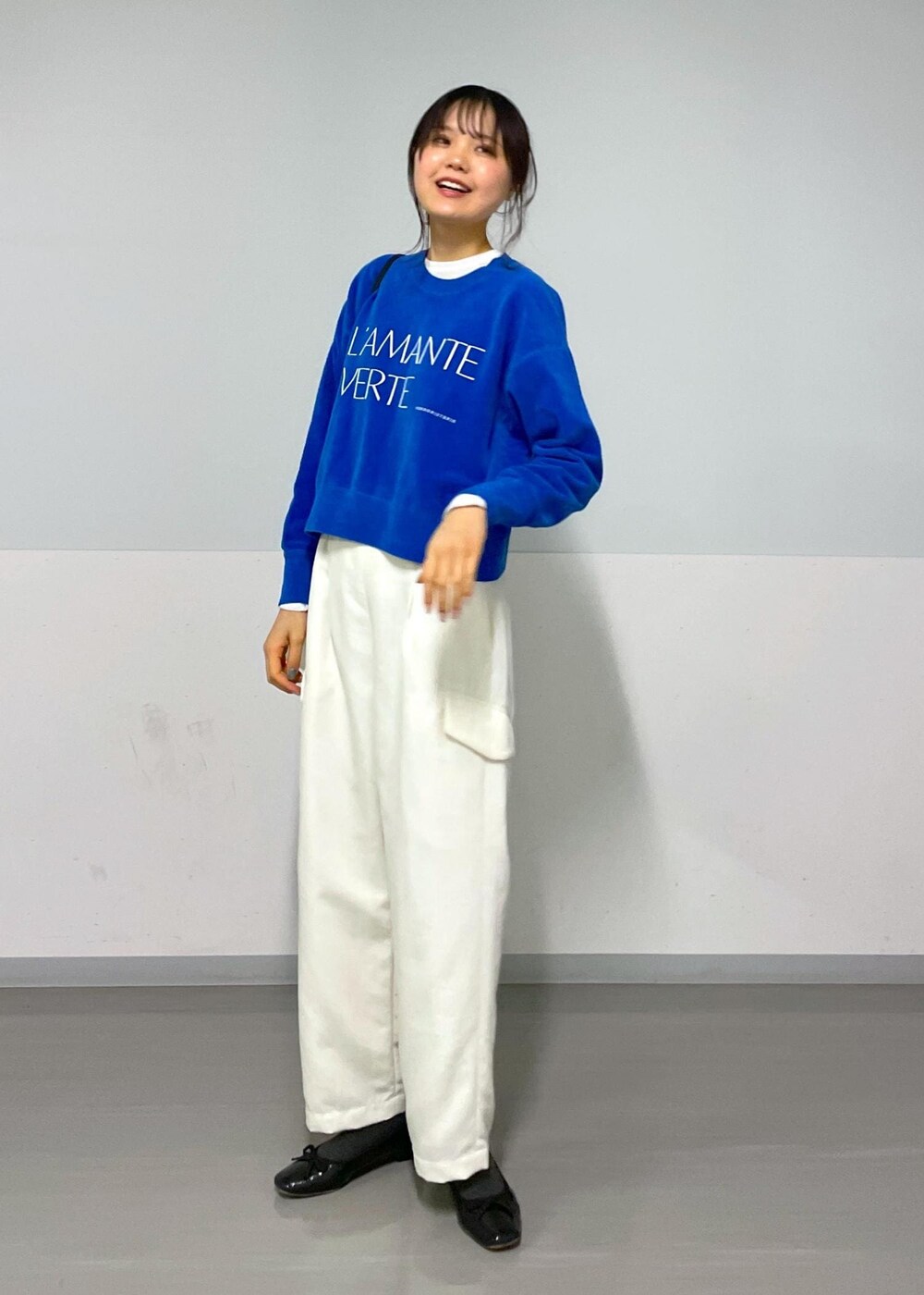 ブルー系のニット/セーター、ホワイト系のカーゴパンツ、ホワイト系のTシャツ/カットソーを着用したレディースの冬コーディネートの2枚目の写真