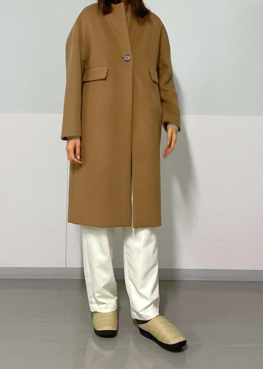 ブラック系のショルダーバッグ、イエロー系のチェスターコート、ベージュ系のカーディガン/ボレロを着用したレディースの冬コーディネートの6枚目の写真