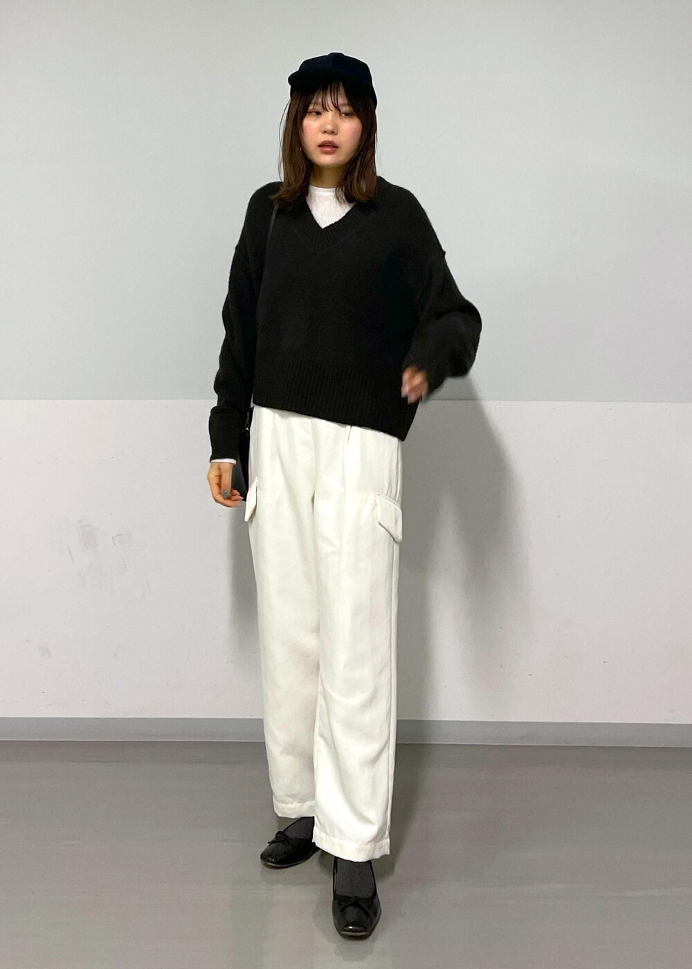 ブラウン系のニット/セーター、ホワイト系のカーゴパンツ、ホワイト系のTシャツ/カットソーを着用したレディースの冬コーディネートの2枚目の写真