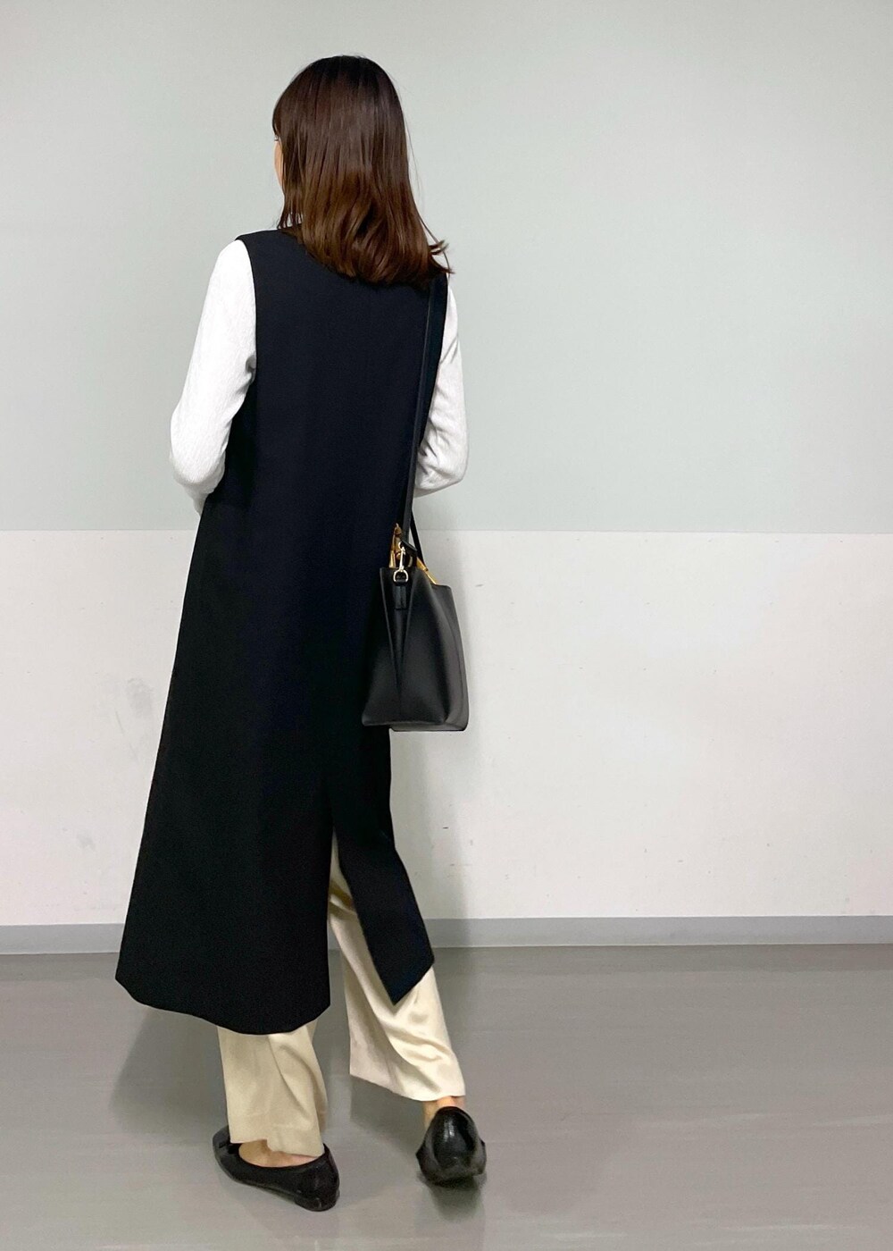 ベージュ系のその他パンツ、ブラック系のジャンパースカート、ホワイト系のTシャツ/カットソーを着用したレディースの冬コーディネートの2枚目の写真