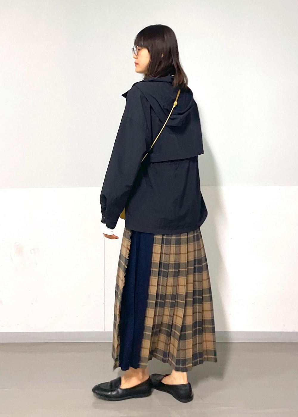 イエロー系のショルダーバッグ、ホワイト系のTシャツ/カットソー、ベージュ系のスカートを着用したレディースの秋コーディネートの2枚目の写真