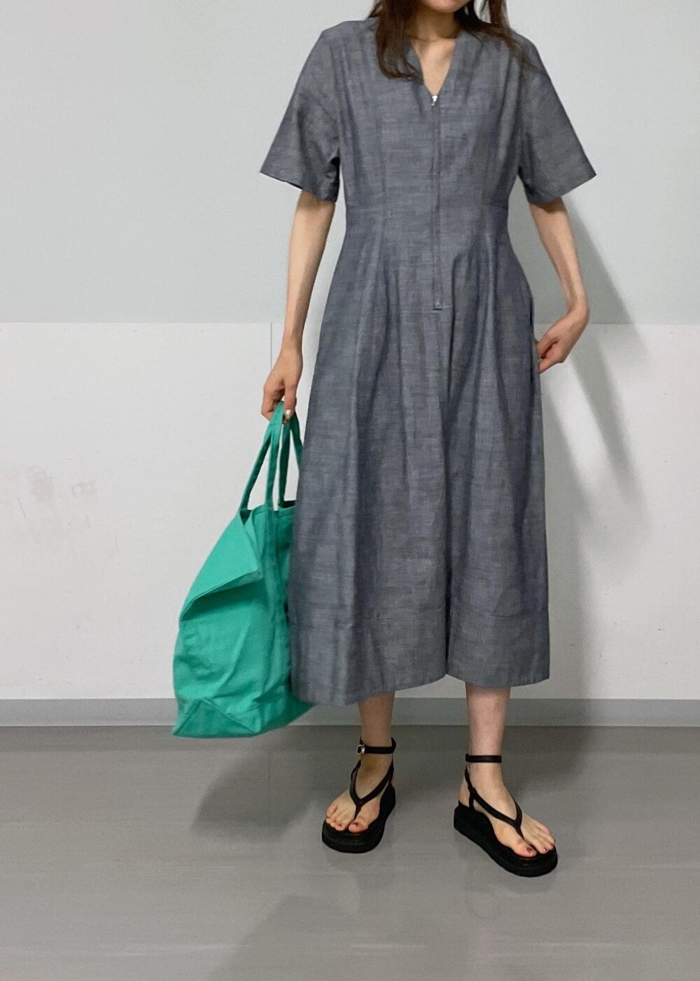ブラック系のサンダル、ブルー系のワンピース、グリーン系のトートバッグを着用したレディースの夏コーディネートの4枚目の写真