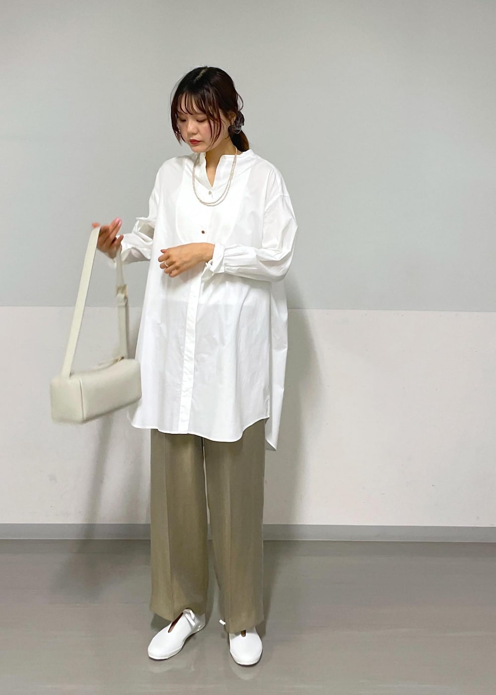 グレー系のその他パンツ、グレー系のショルダーバッグ、ホワイト系のシャツ/ブラウスを着用したレディースの夏コーディネートの2枚目の写真