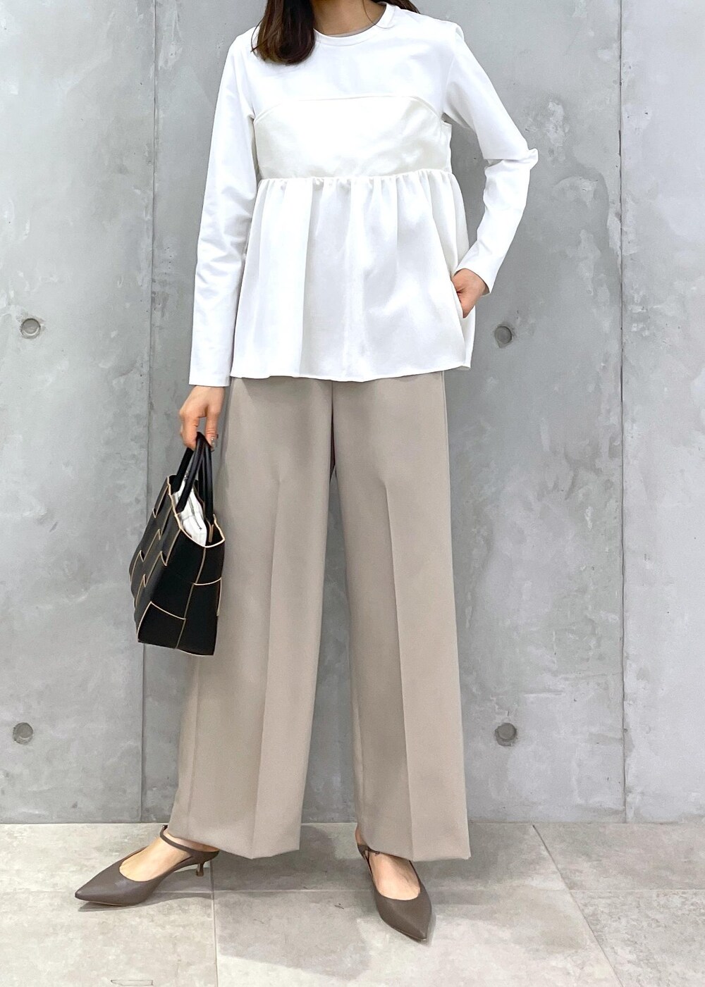 ベージュ系のその他パンツ、ブラック系のトートバッグ、ホワイト系のTシャツ/カットソーを着用したレディースの冬コーディネートの6枚目の写真