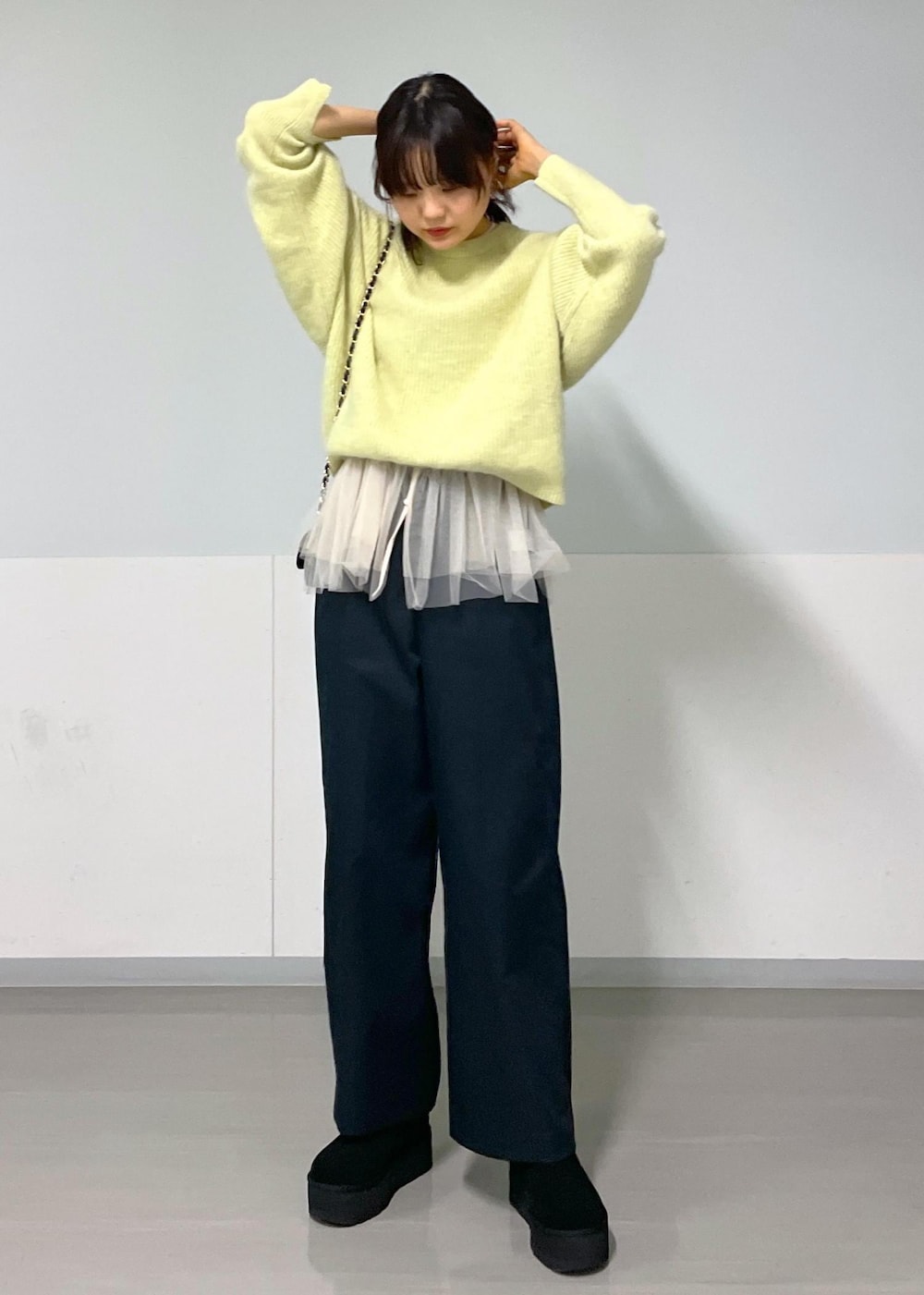 ブラック系のショルダーバッグ、ブラック系のその他パンツ、イエロー系のニット/セーターを着用したレディースの秋コーディネートの2枚目の写真