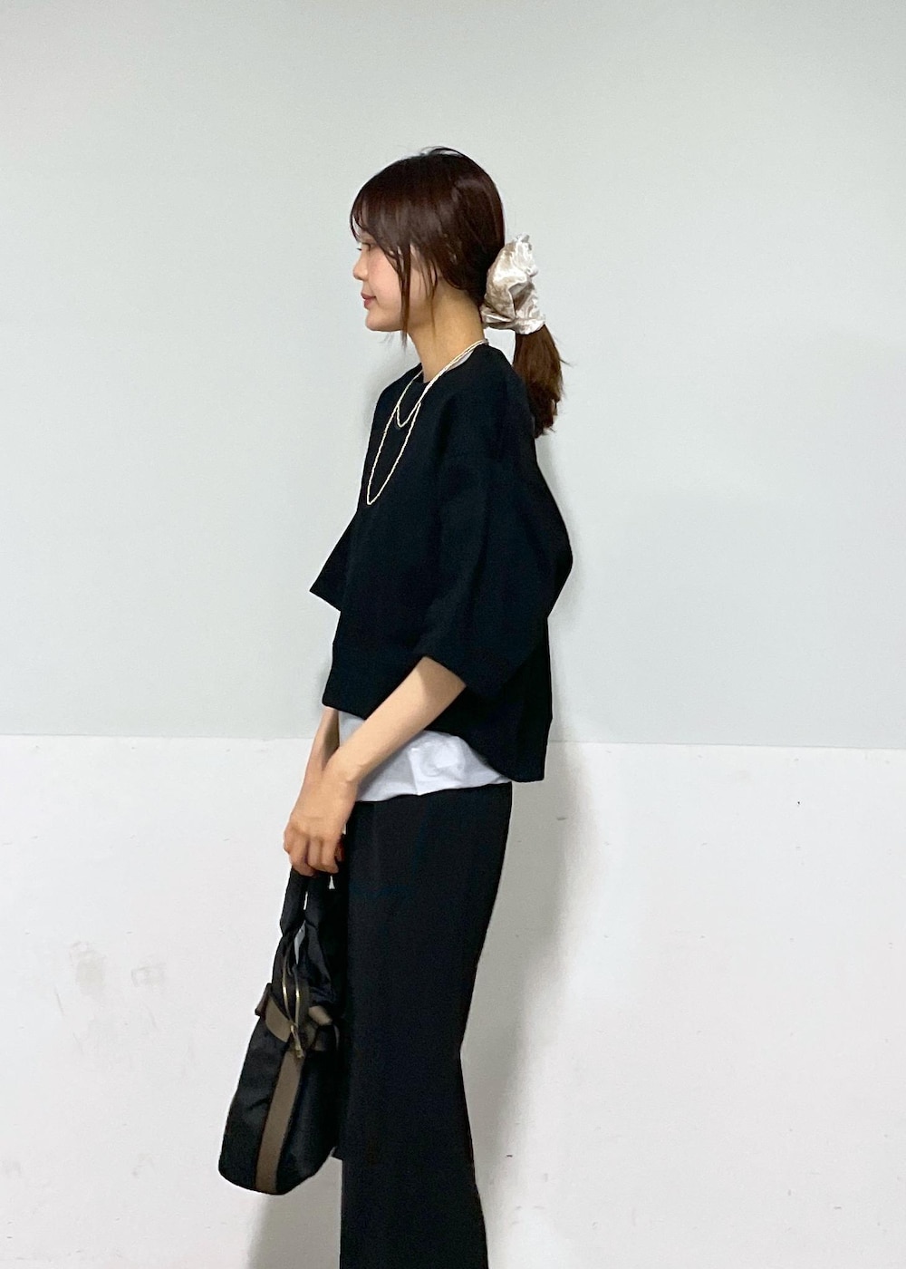 ブラック系のスラックス、シルバー系のサンダル、ブラック系のトートバッグを着用したレディースの夏コーディネートの3枚目の写真