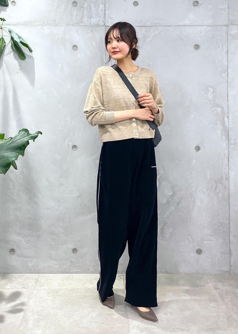 ブラック系のショルダーバッグ、ブラック系のその他パンツ、ベージュ系のカーディガン/ボレロを着用したレディースの冬コーディネートの2枚目の写真