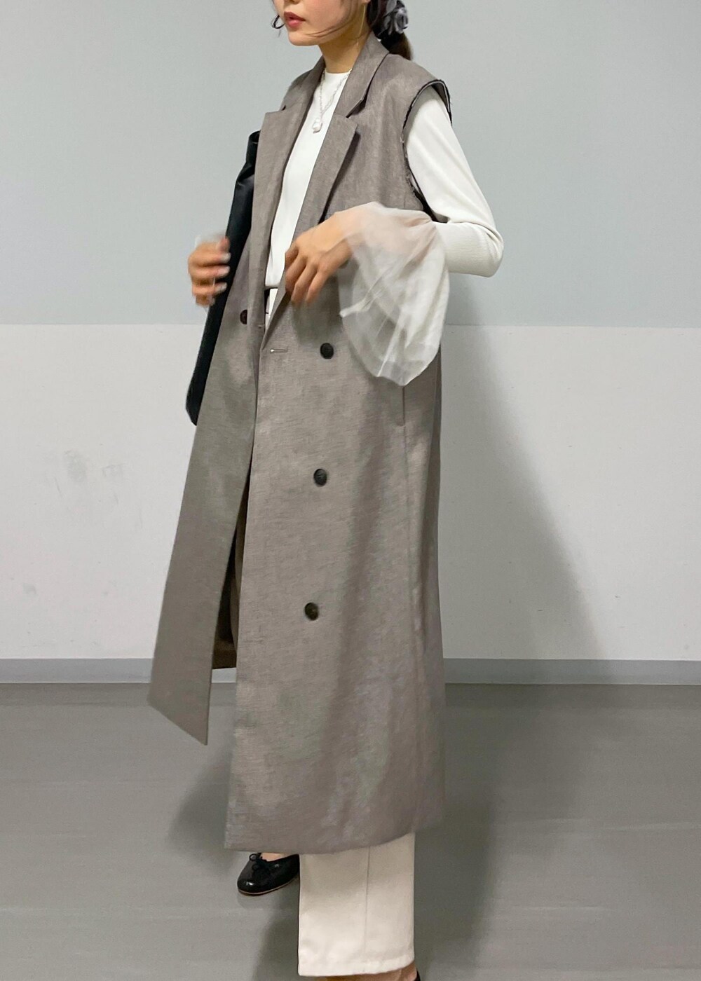 ベージュ系のジャンパースカート、ホワイト系のTシャツ/カットソー、ブラック系のバレエシューズを着用したレディースの秋コーディネートの2枚目の写真