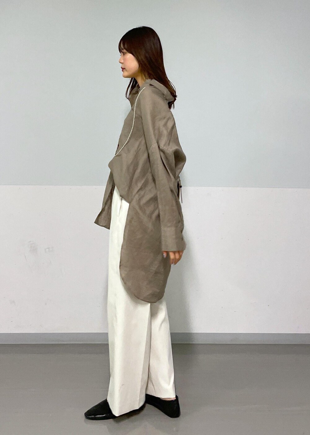 ブラック系のショルダーバッグ、グリーン系のシャツ/ブラウス、ホワイト系のその他パンツを着用したレディースの春コーディネートの2枚目の写真