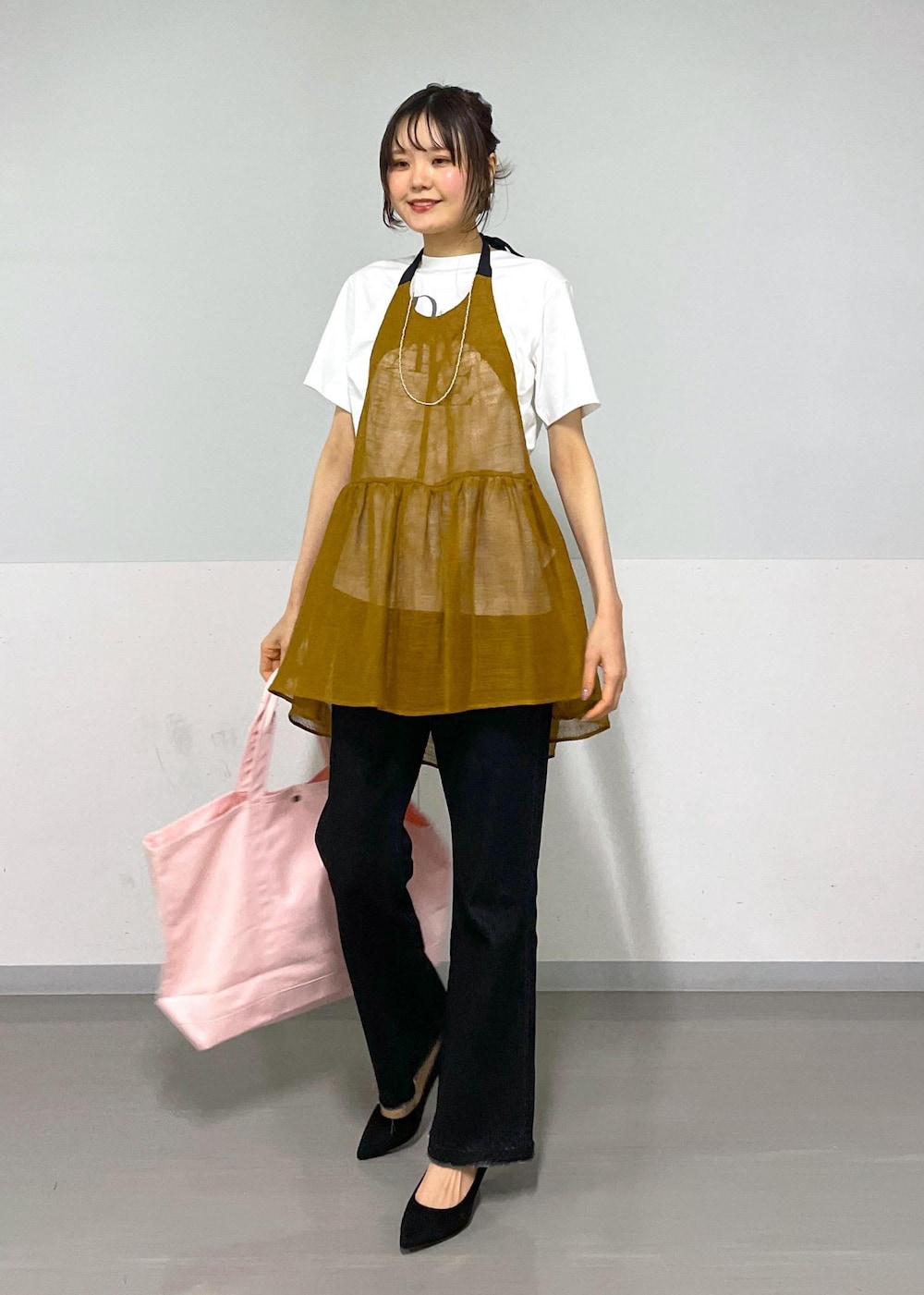 グレー系のデニムパンツ、ホワイト系のTシャツ/カットソー、ブラウン系のベストを着用したレディースの春コーディネートの10枚目の写真