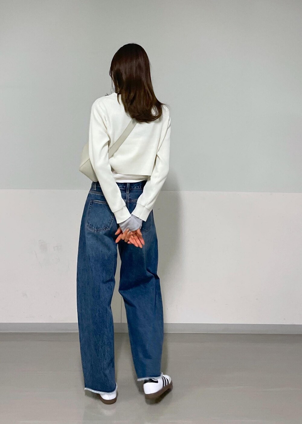 グレー系のショルダーバッグ、ホワイト系のカーディガン/ボレロ、グレー系のTシャツ/カットソーを着用したレディースの夏コーディネートの3枚目の写真