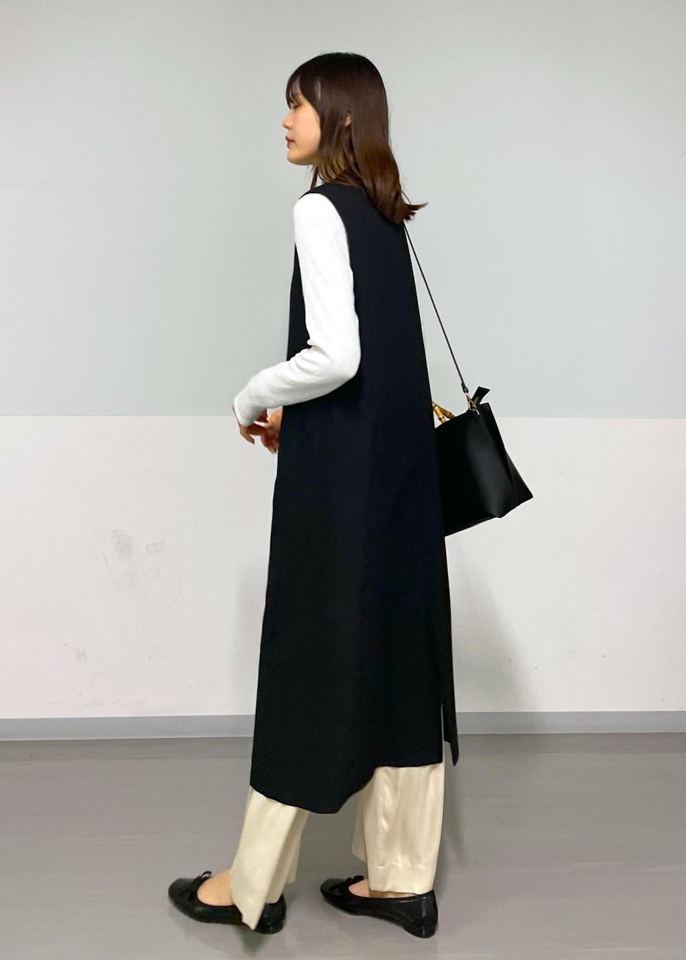 ベージュ系のその他パンツ、ブラック系のジャンパースカート、ホワイト系のTシャツ/カットソーを着用したレディースの冬コーディネートの3枚目の写真