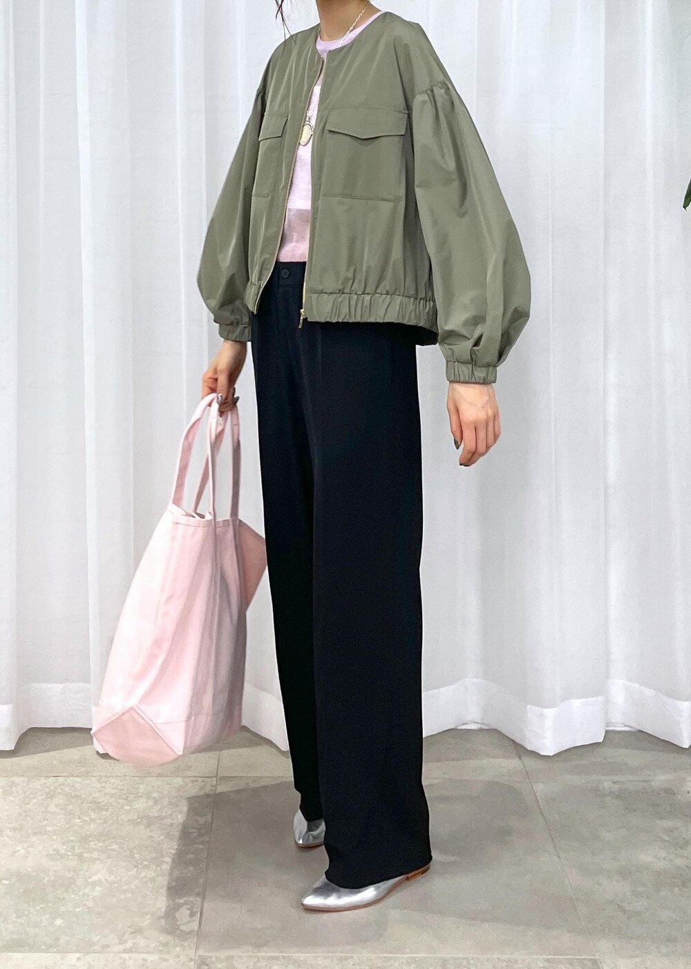 ブラック系のスラックス、グリーン系のブルゾン、シルバー系のパンプスを着用したレディースの冬コーディネートの2枚目の写真