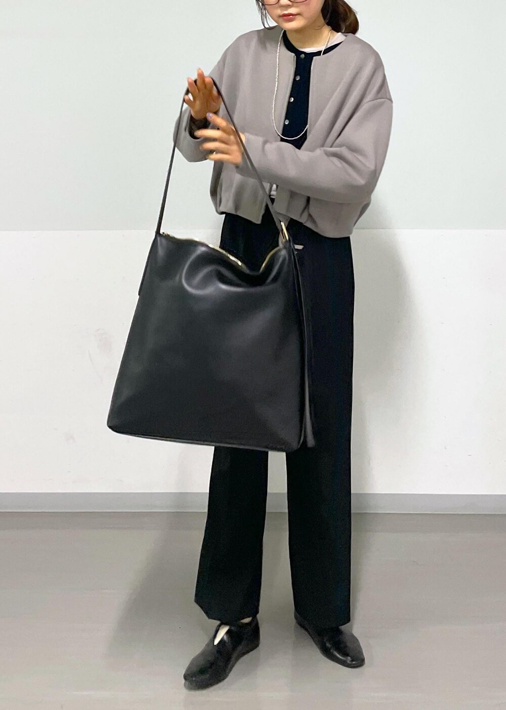 ブラック系のカーディガン/ボレロ、グレー系のTシャツ/カットソー、ブラック系のショルダーバッグを着用したレディースの春コーディネートの8枚目の写真