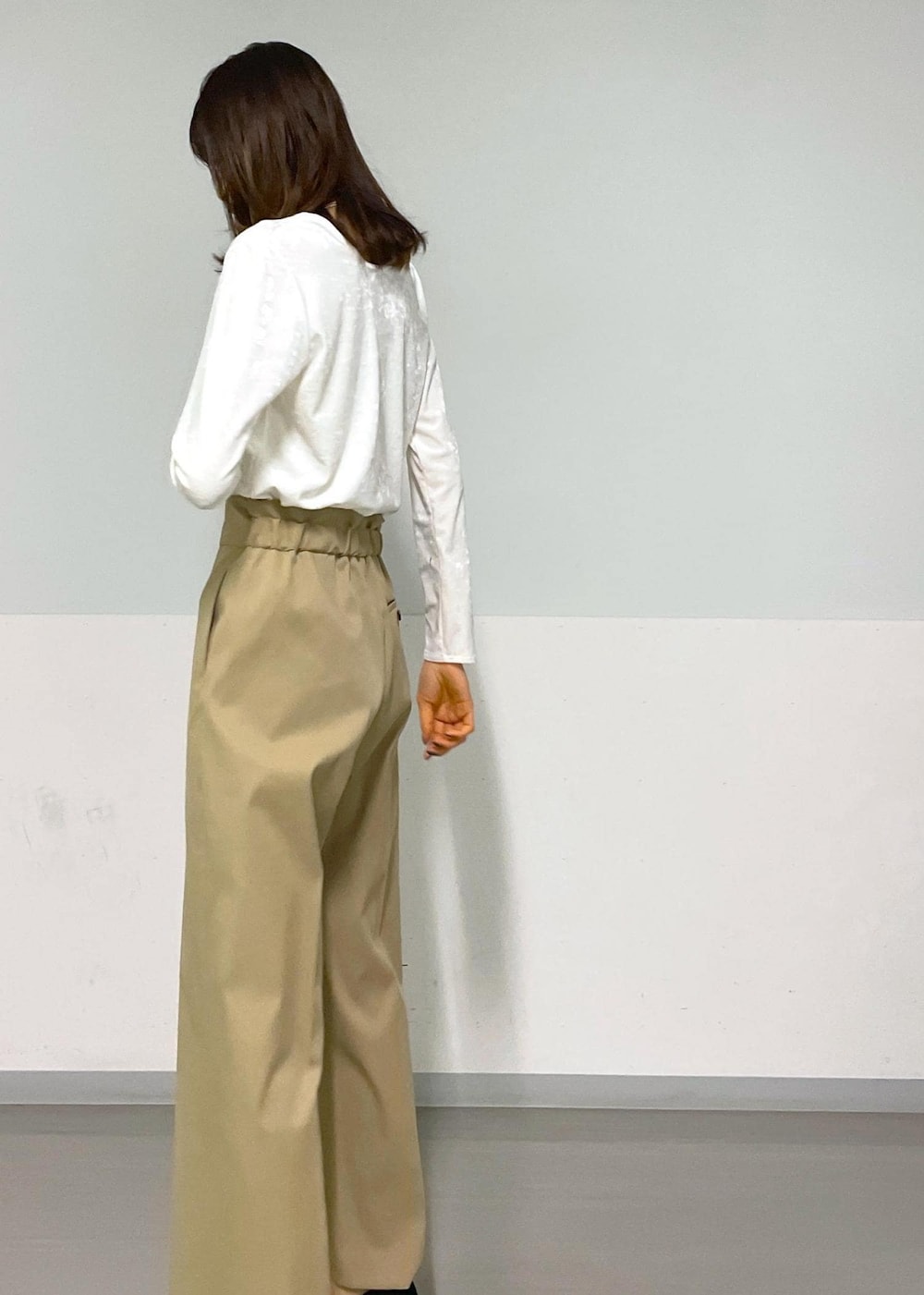 ブラック系のトートバッグ、ベージュ系のその他パンツ、ホワイト系のTシャツ/カットソーを着用したレディースの冬コーディネートの8枚目の写真