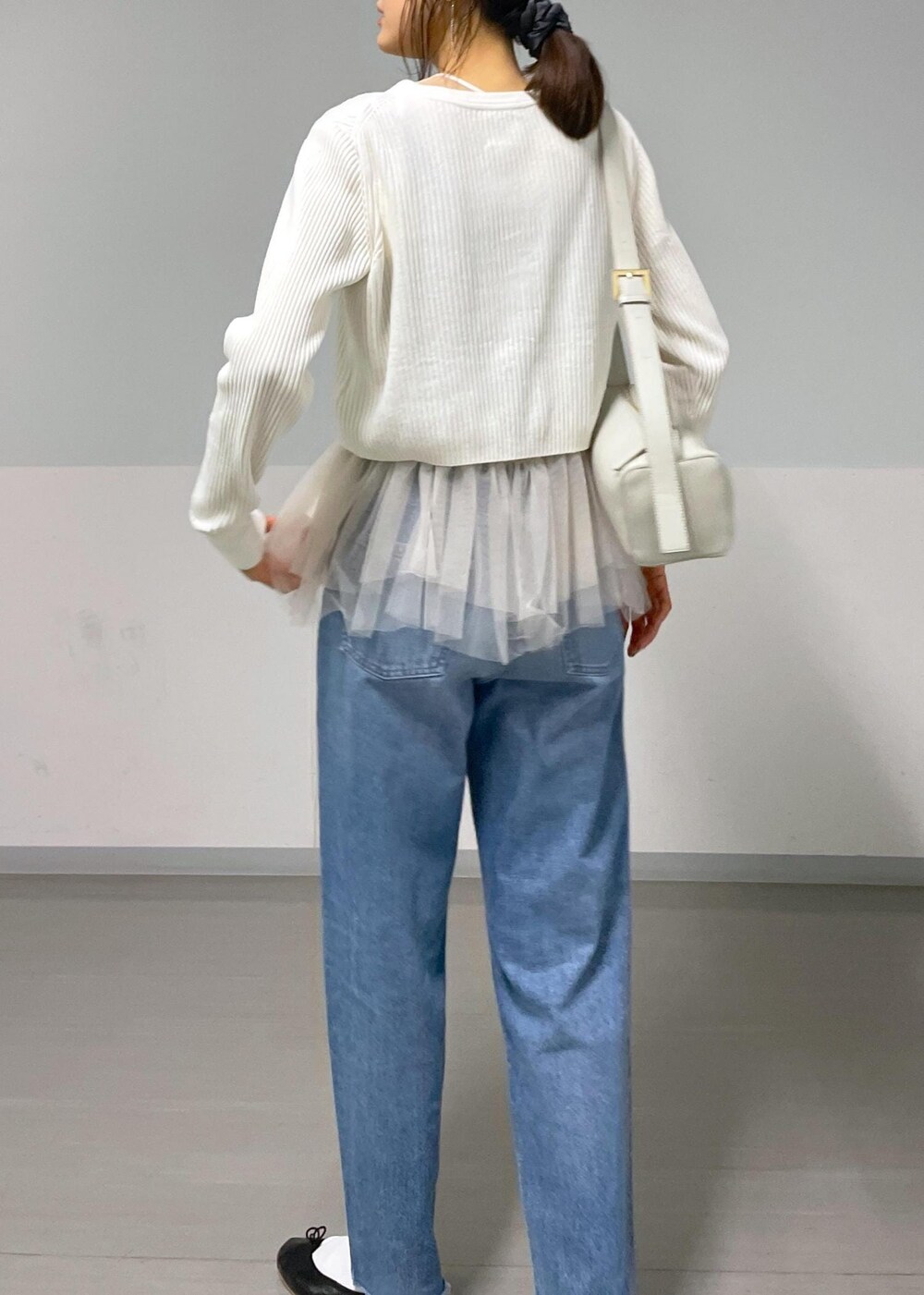 ブラック系のバレエシューズ、ホワイト系のカーディガン/ボレロ、ブルー系のデニムパンツを着用したレディースの秋コーディネートの6枚目の写真