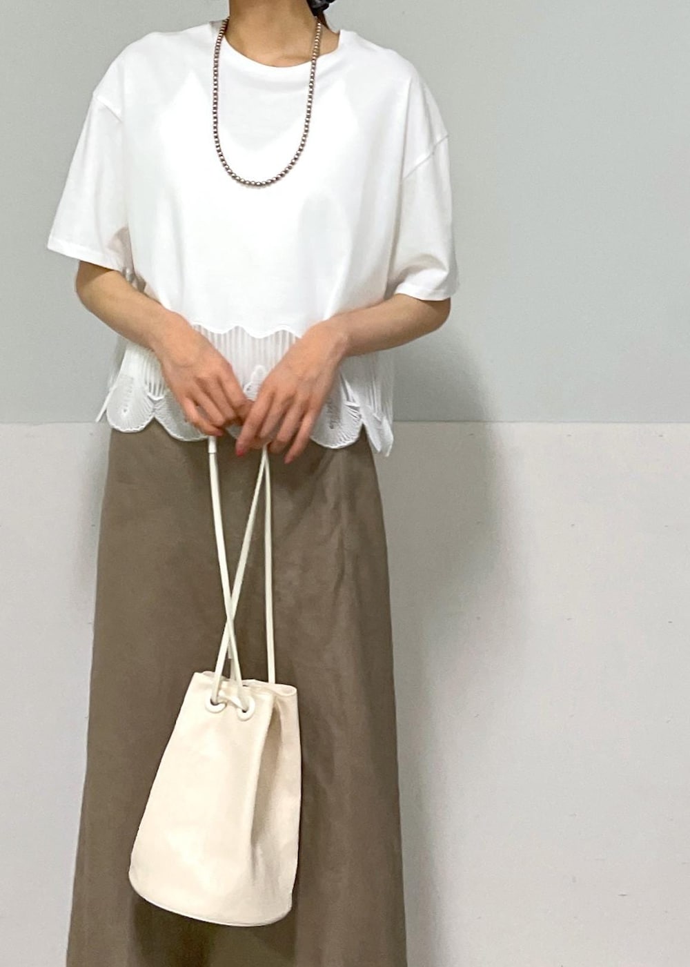 ホワイト系のキャミソール、シルバー系のサンダル、グリーン系のスカートを着用したレディースの夏コーディネートの3枚目の写真