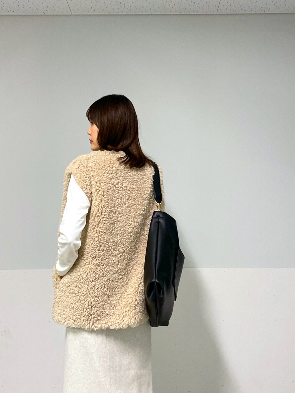 ホワイト系のカーディガン/ボレロ、ベージュ系のベスト、ホワイト系のスカートを着用したレディースの冬コーディネートの5枚目の写真