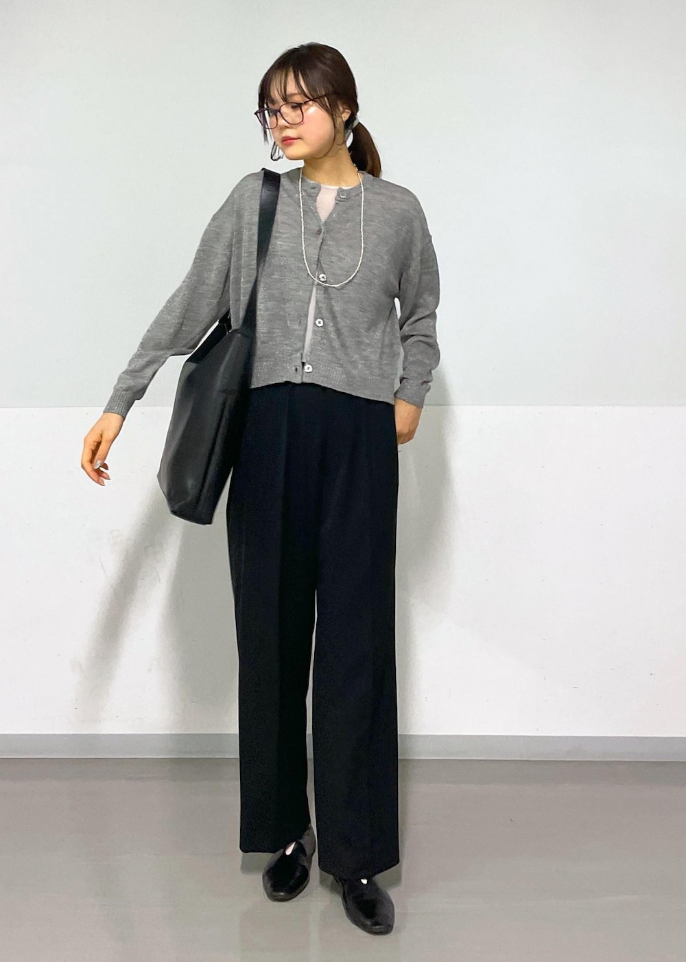 グレー系のカーディガン/ボレロ、グレー系のTシャツ/カットソー、ブラック系のスラックスを着用したレディースの春コーディネートの3枚目の写真