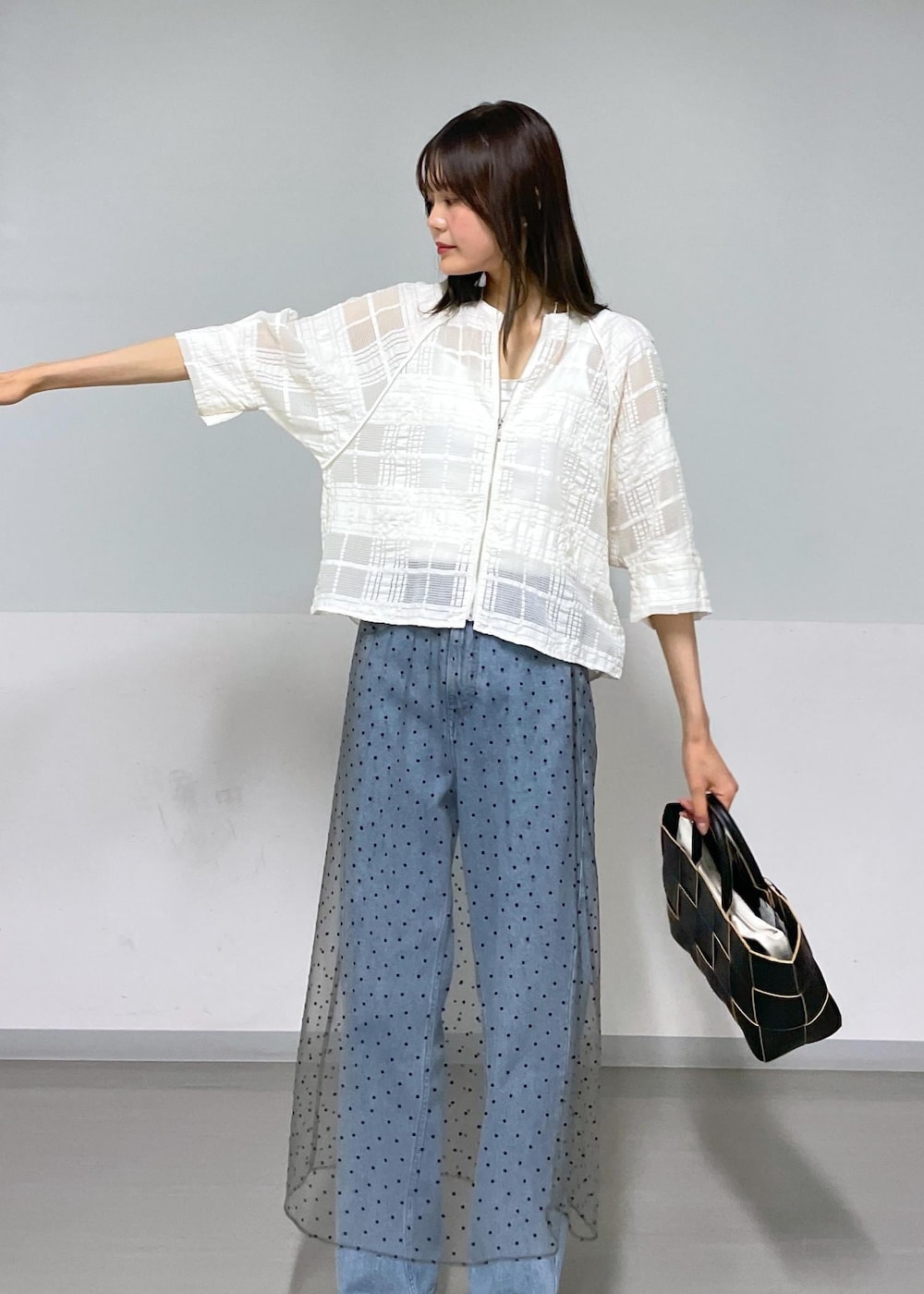 ブラック系のトートバッグ、ホワイト系のタンクトップ、グレー系のスカートを着用したレディースの夏コーディネートの2枚目の写真