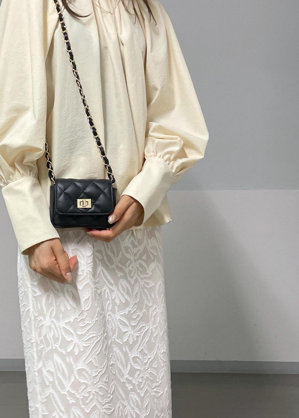 ブラック系のショルダーバッグ、ブラック系のサンダル、グリーン系のタンクトップを着用したレディースの夏コーディネートの6枚目の写真