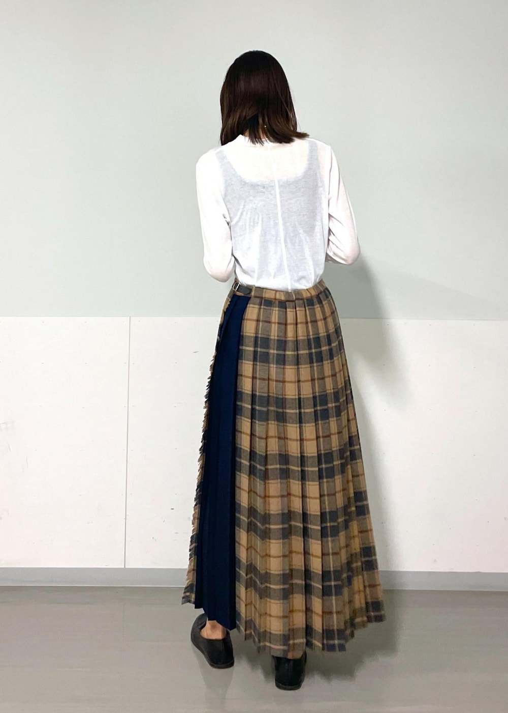 イエロー系のショルダーバッグ、ホワイト系のTシャツ/カットソー、ベージュ系のスカートを着用したレディースの秋コーディネートの9枚目の写真