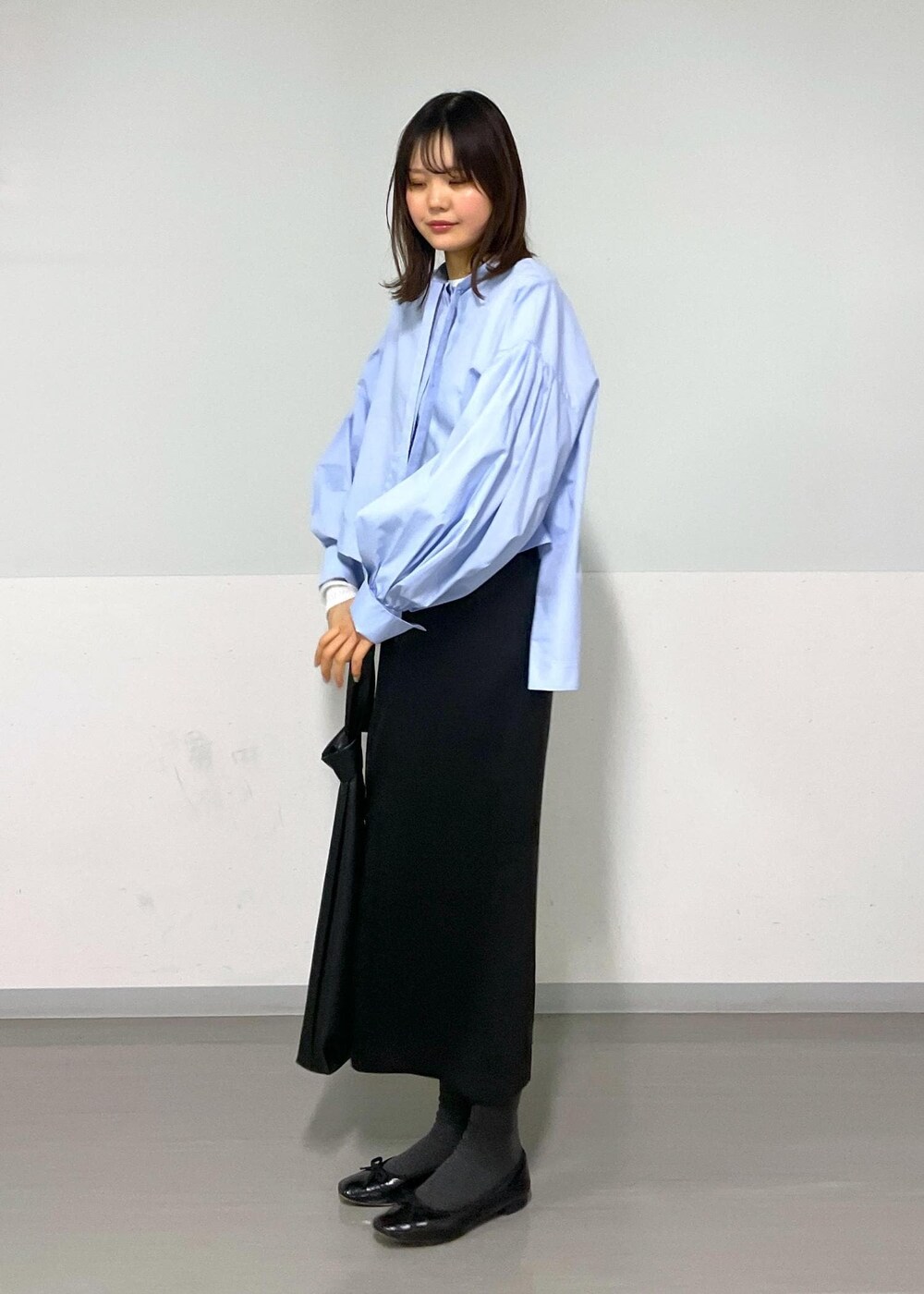 ブルー系のシャツ/ブラウス、ブラック系のトートバッグ、ブラック系のスカートを着用したレディースの冬コーディネートの7枚目の写真