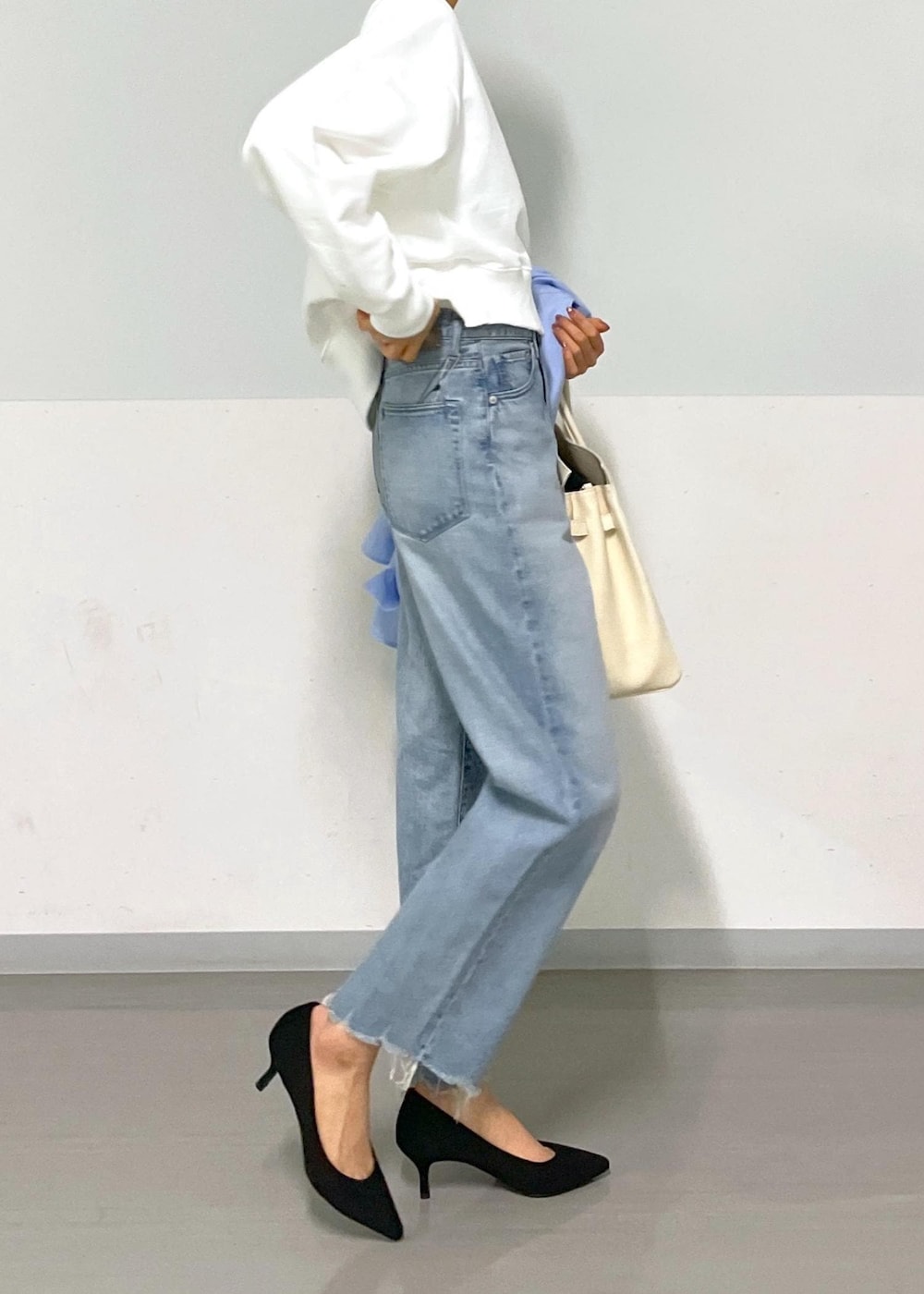 ブルー系のシャツ/ブラウス、ホワイト系のスウェット、ブルー系のデニムパンツを着用したレディースの冬コーディネートの8枚目の写真