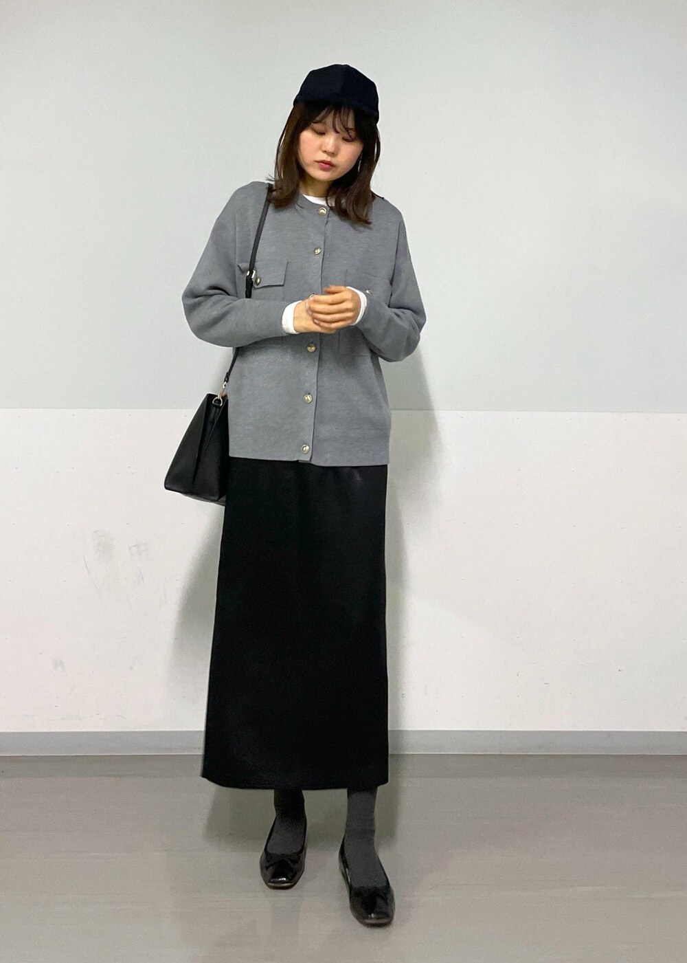 グレー系のカーディガン/ボレロ、ホワイト系のTシャツ/カットソー、ブラック系のハンドバッグを着用したレディースの冬コーディネートの8枚目の写真