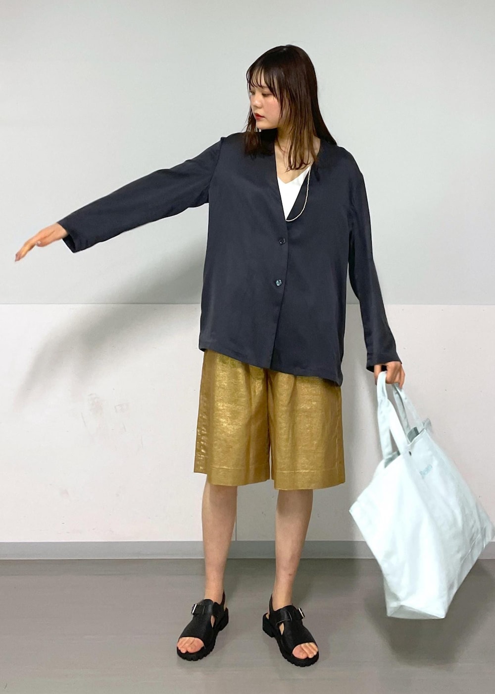 ゴールド系のその他パンツ、グレー系のノーカラージャケット、ブラック系のサンダルを着用したレディースの春コーディネートの5枚目の写真