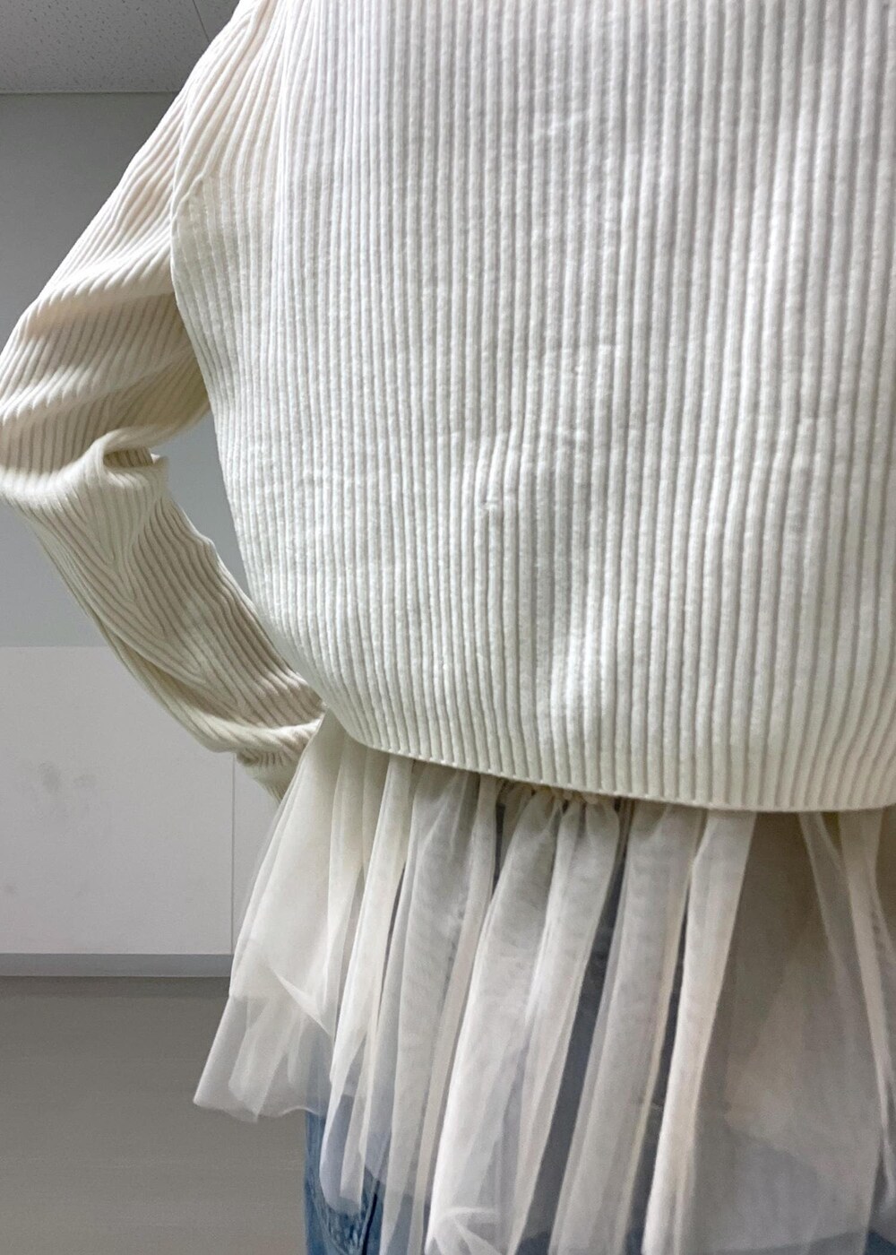 ブラック系のバレエシューズ、ホワイト系のカーディガン/ボレロ、ブルー系のデニムパンツを着用したレディースの秋コーディネートの5枚目の写真