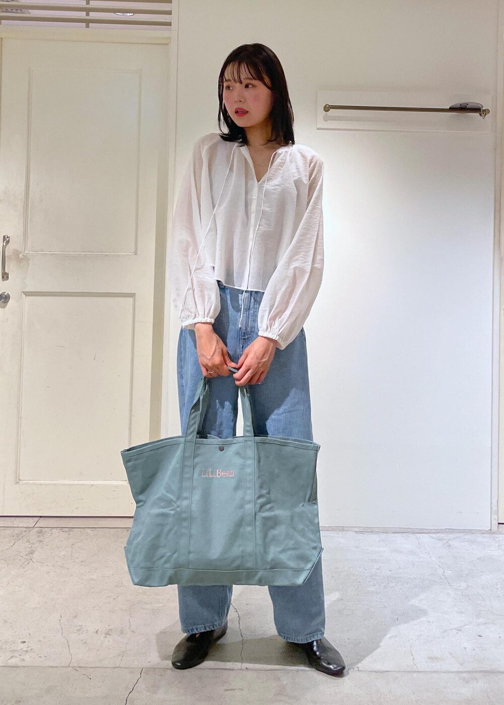 グレー系のタンクトップ、ホワイト系のシャツ/ブラウス、ブルー系のデニムパンツを着用したレディースの夏コーディネートの9枚目の写真