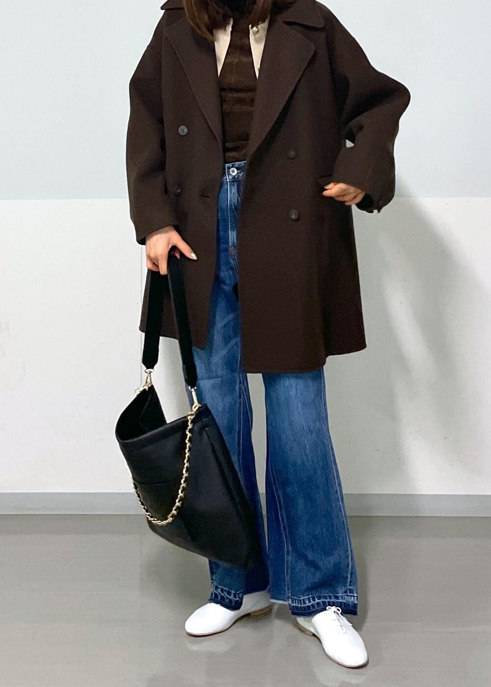 ブラウン系のピーコート、ブラック系のトートバッグ、ブラウン系のTシャツ/カットソーを着用したレディースの冬コーディネートの4枚目の写真