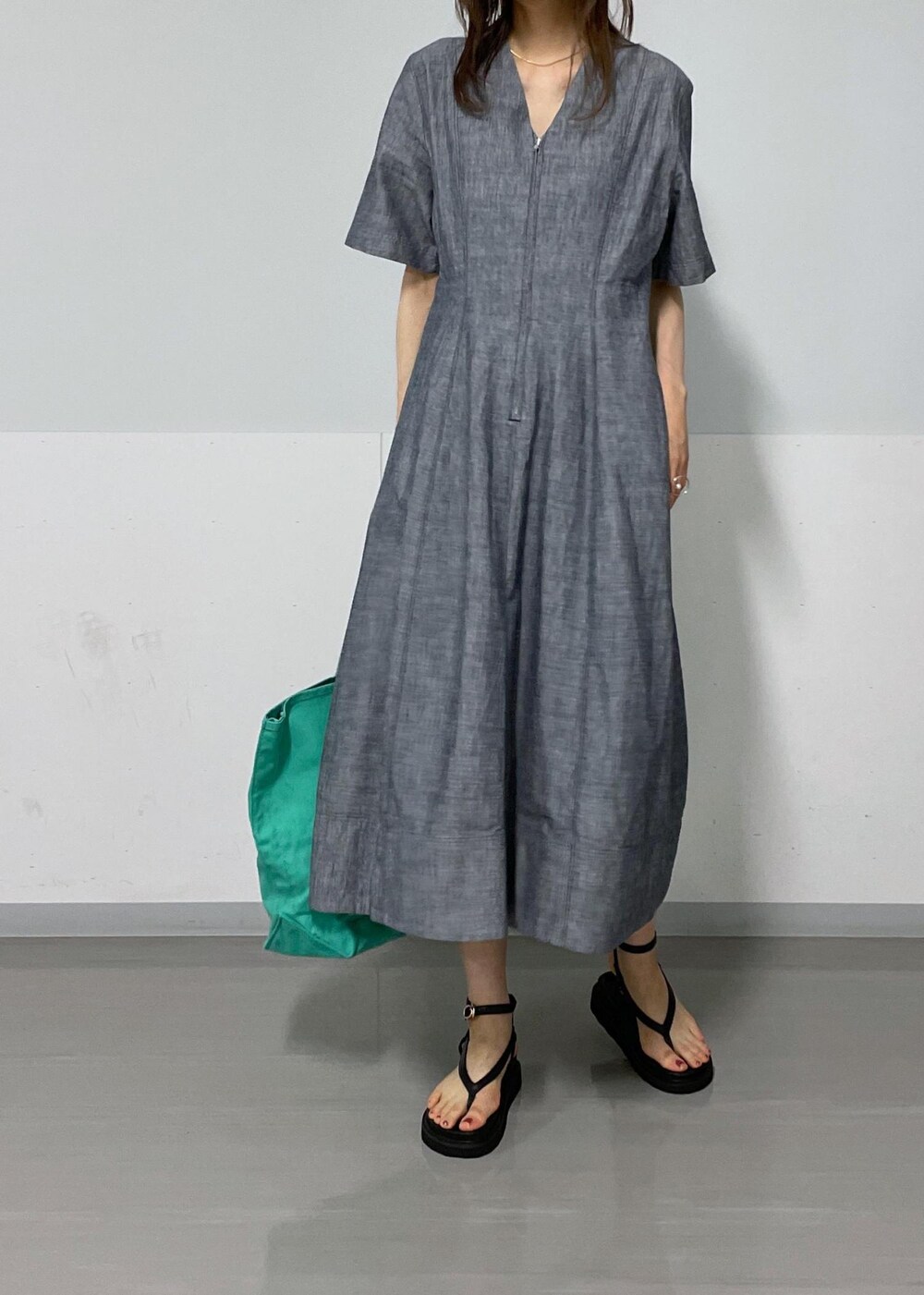 ブラック系のサンダル、ブルー系のワンピース、グリーン系のトートバッグを着用したレディースの夏コーディネートの6枚目の写真