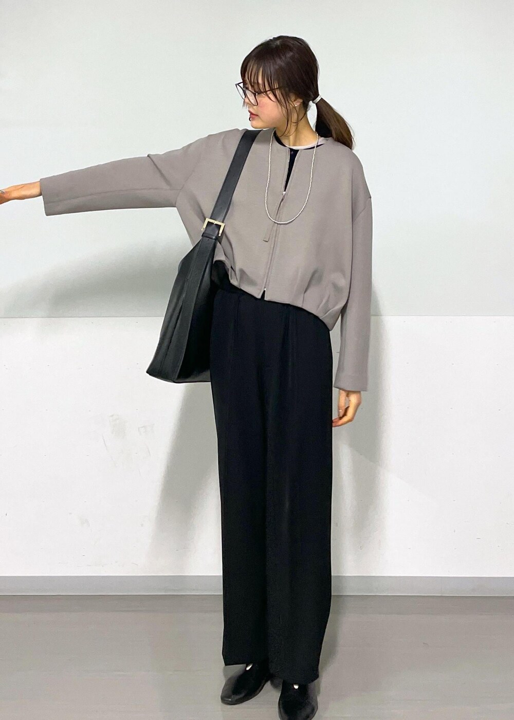 ブラック系のカーディガン/ボレロ、グレー系のTシャツ/カットソー、ブラック系のショルダーバッグを着用したレディースの春コーディネートの3枚目の写真