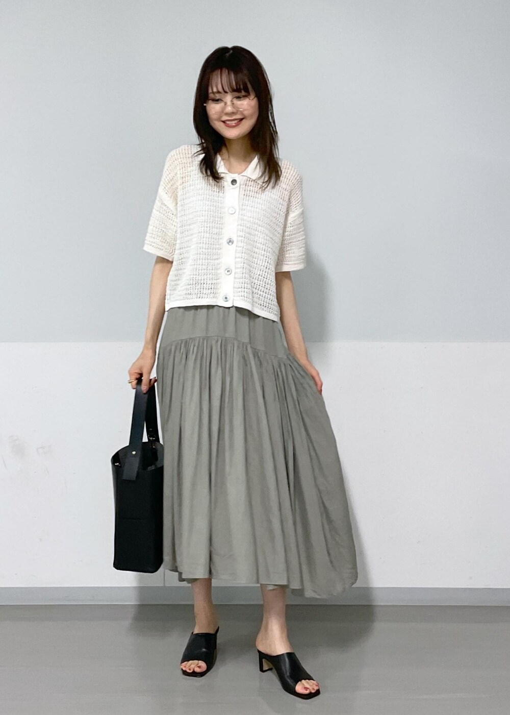 ブラック系のサンダル、ブラック系のトートバッグ、グレー系のスカートを着用したレディースの春コーディネートの2枚目の写真