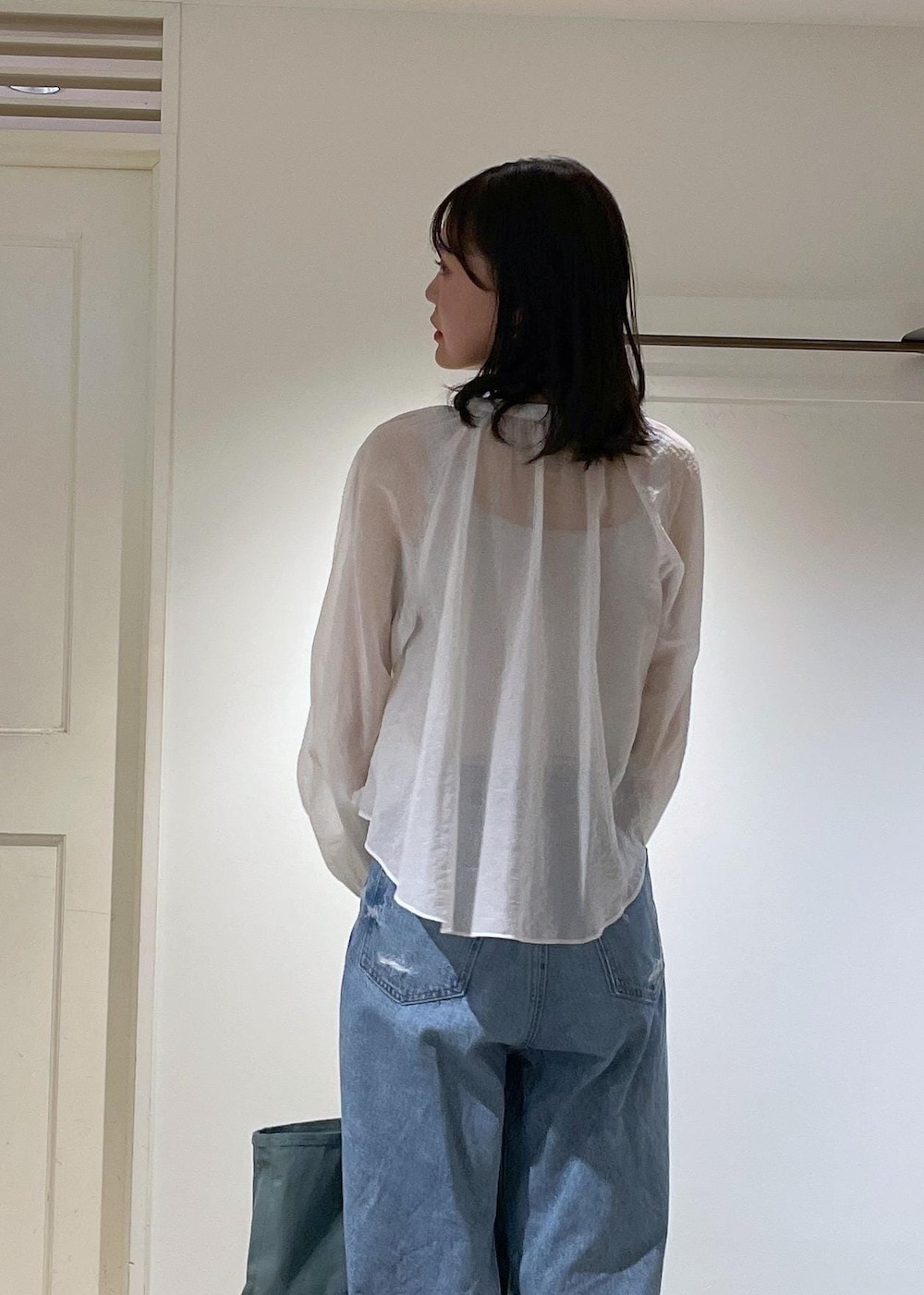 グレー系のタンクトップ、ホワイト系のシャツ/ブラウス、ブルー系のデニムパンツを着用したレディースの夏コーディネートの4枚目の写真