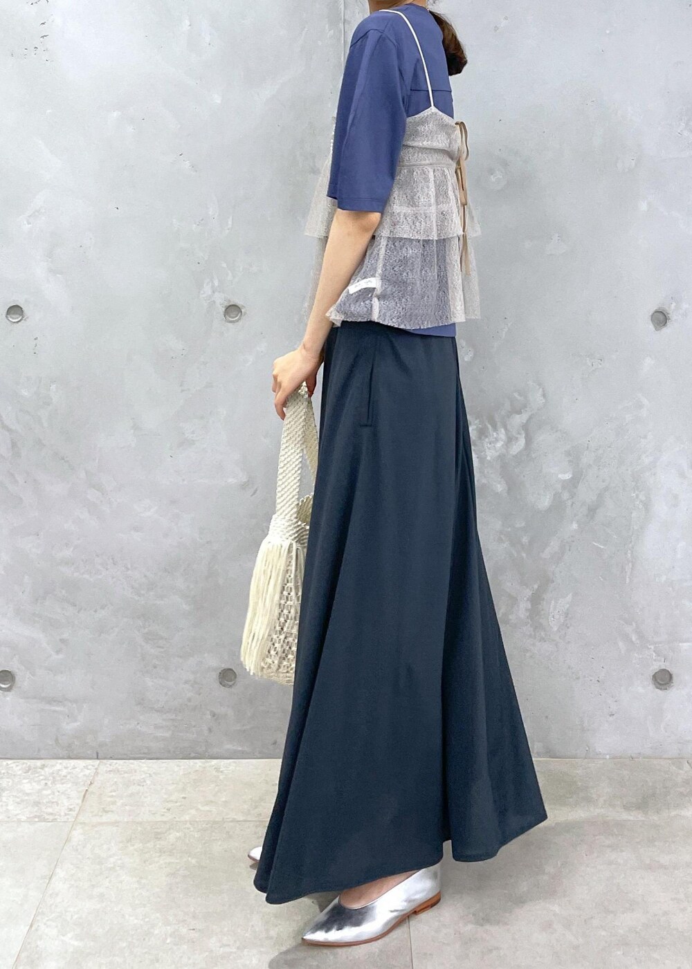 ホワイト系のハンドバッグ、ブルー系のTシャツ/カットソー、ブラウン系のキャミソールを着用したレディースの春コーディネートの3枚目の写真