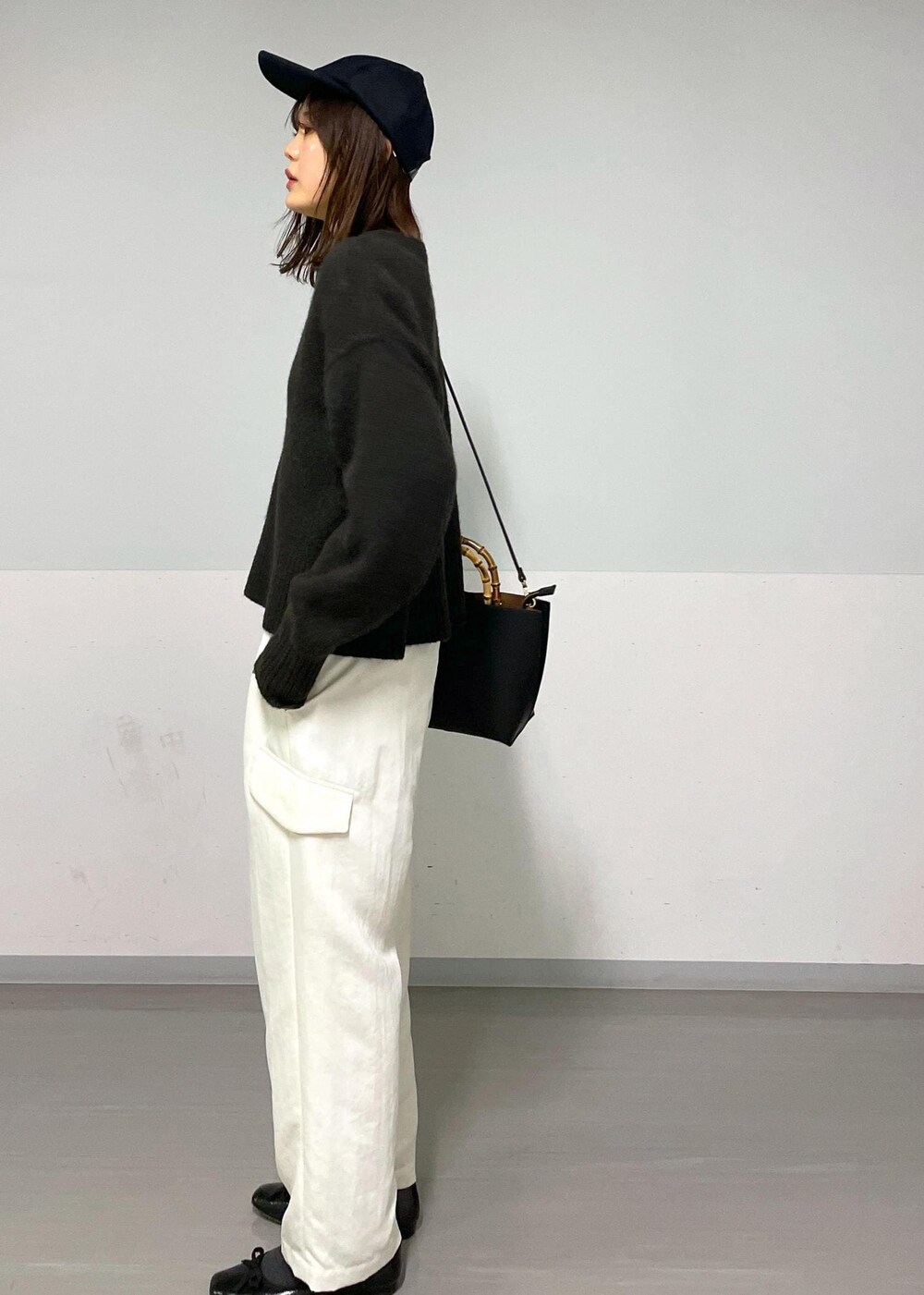 ブラウン系のニット/セーター、ホワイト系のカーゴパンツ、ホワイト系のTシャツ/カットソーを着用したレディースの冬コーディネートの10枚目の写真