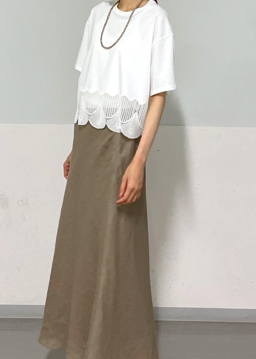 ホワイト系のキャミソール、シルバー系のサンダル、グリーン系のスカートを着用したレディースの夏コーディネートの4枚目の写真