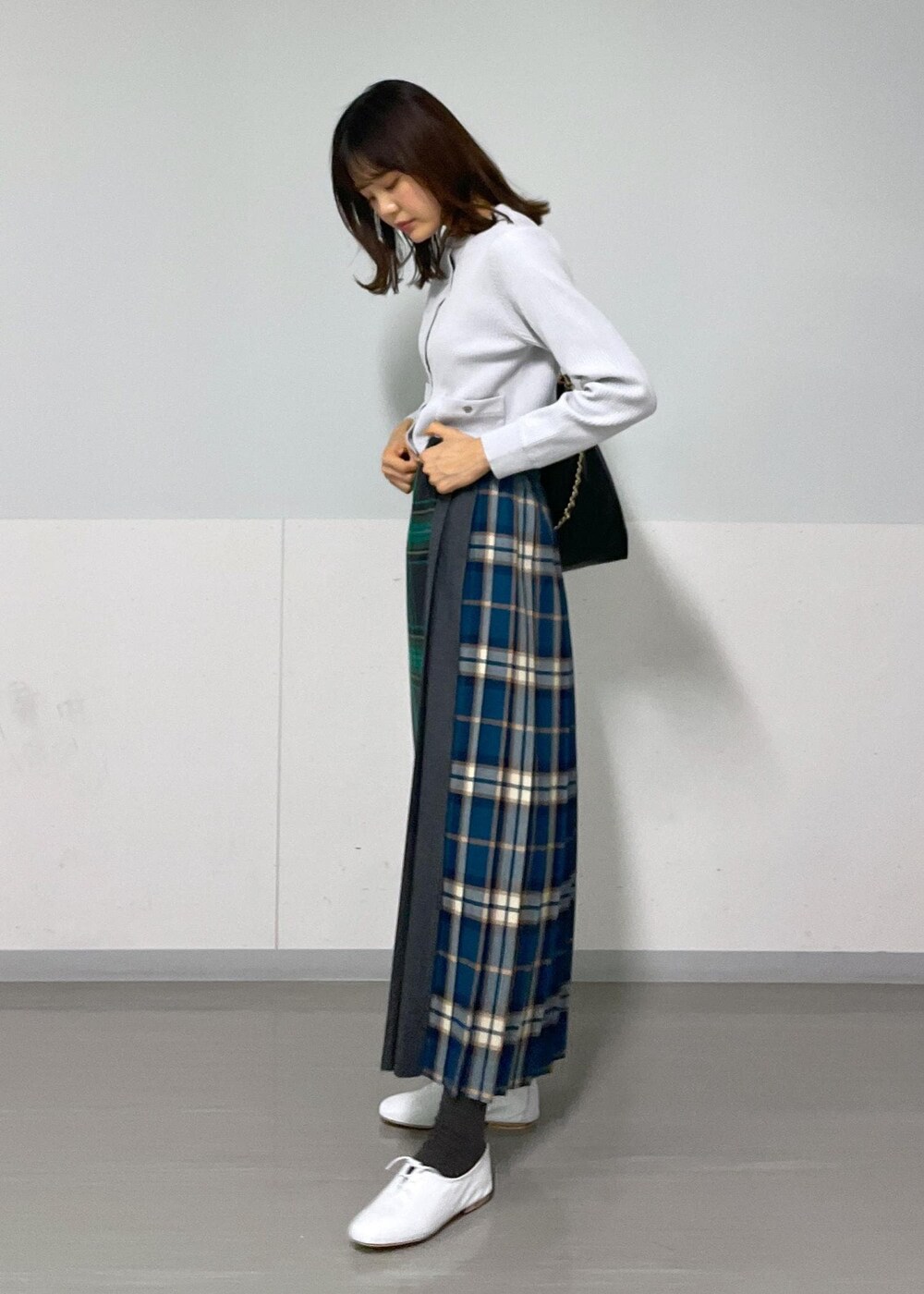 グリーン系のスカート、ホワイト系のその他シューズ、グレー系のカーディガン/ボレロを着用したレディースの冬コーディネートの3枚目の写真