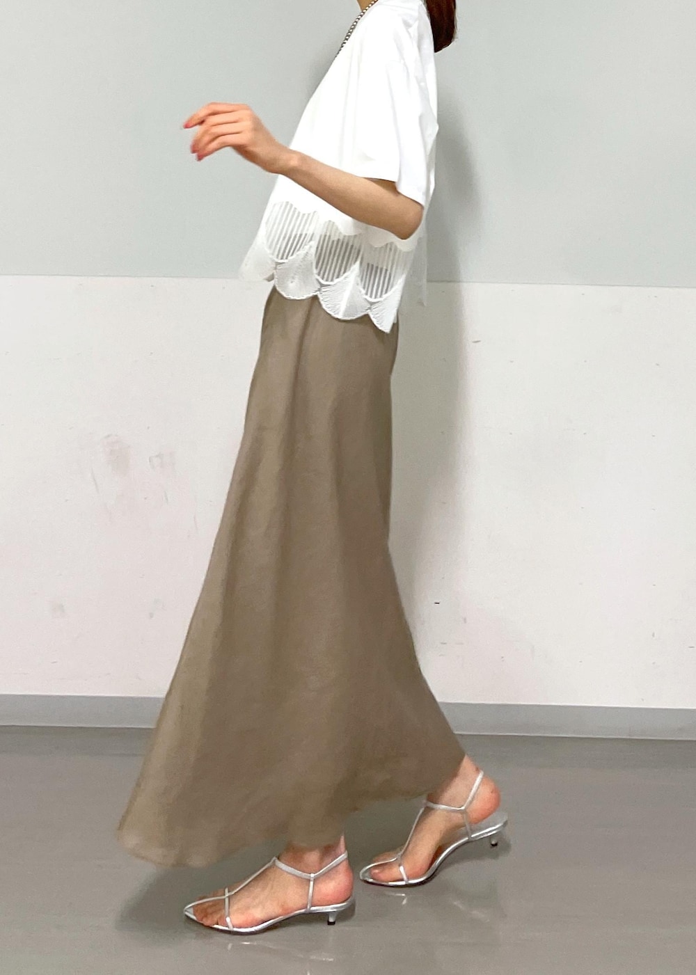 ホワイト系のキャミソール、シルバー系のサンダル、グリーン系のスカートを着用したレディースの夏コーディネートの6枚目の写真