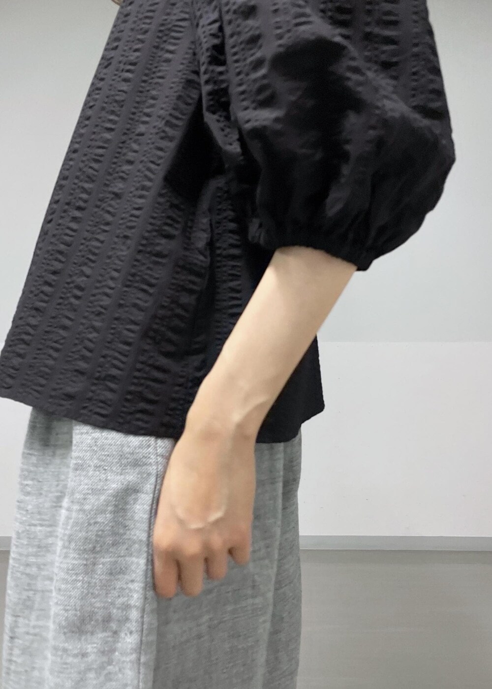 ブラック系のショルダーバッグ、グレー系のスラックス、ブラック系のシャツ/ブラウスを着用したレディースの夏コーディネートの5枚目の写真