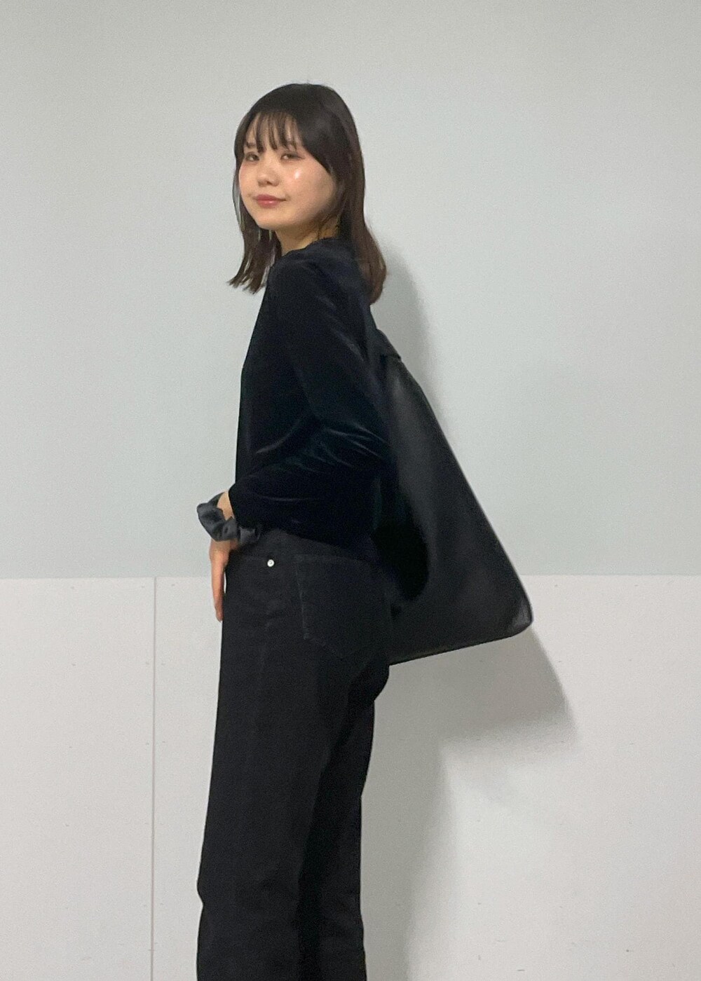 グレー系のTシャツ/カットソー、ブラック系のトートバッグ、グレー系のデニムパンツを着用したレディースの冬コーディネートの8枚目の写真