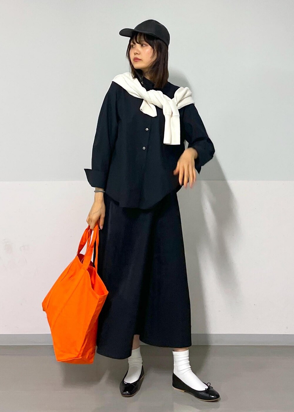 ブラック系のスカート、ブラック系のバレエシューズ、ホワイト系のカーディガン/ボレロを着用したレディースの秋コーディネートの2枚目の写真